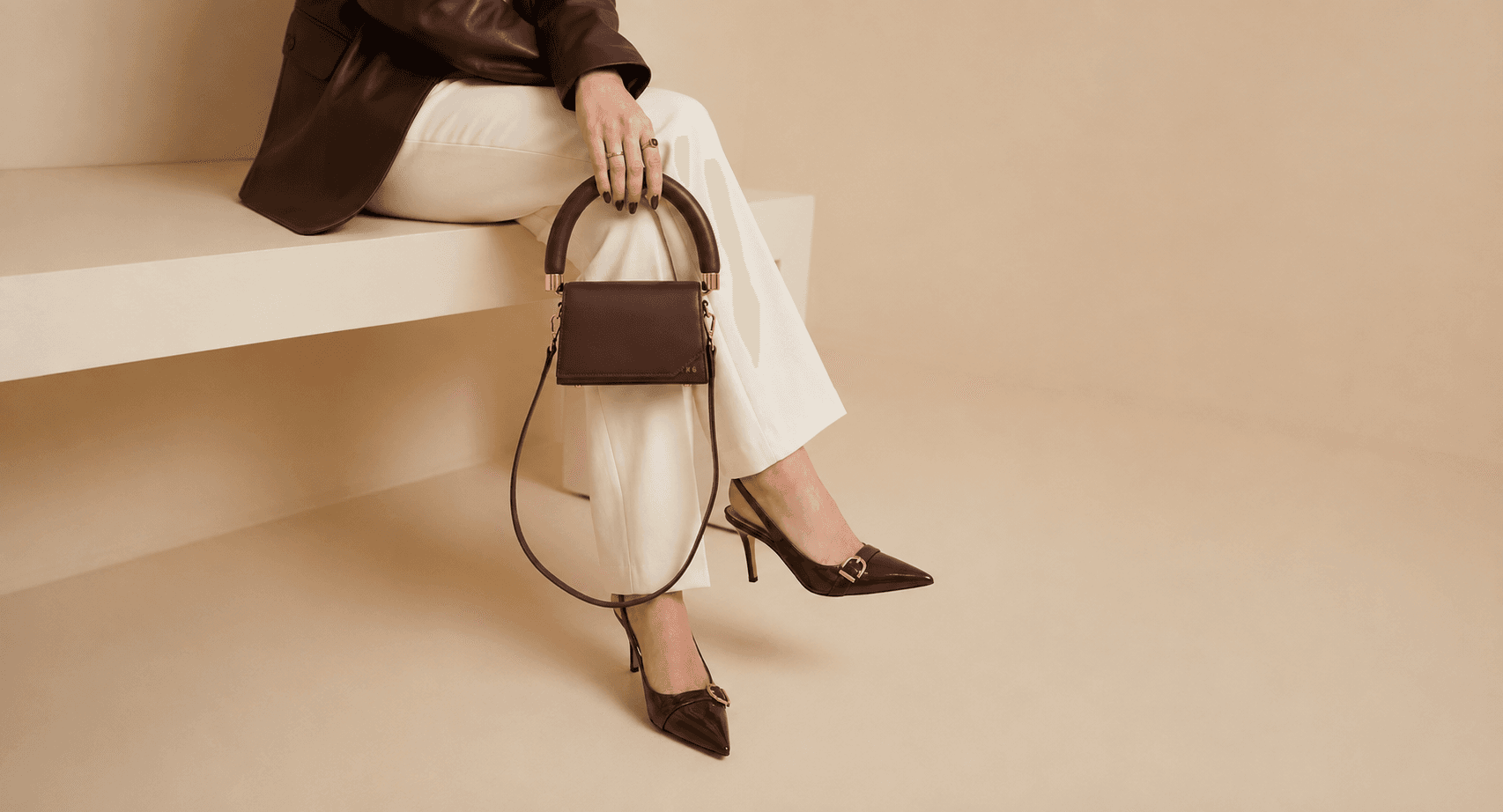 Chocolate brown handbag and pointed heels styled with ivory trousers